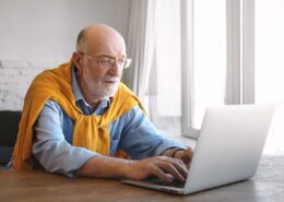 susikaupes stilingas pagyvenes vyras su akiniais naudojasi kompiuteriu
